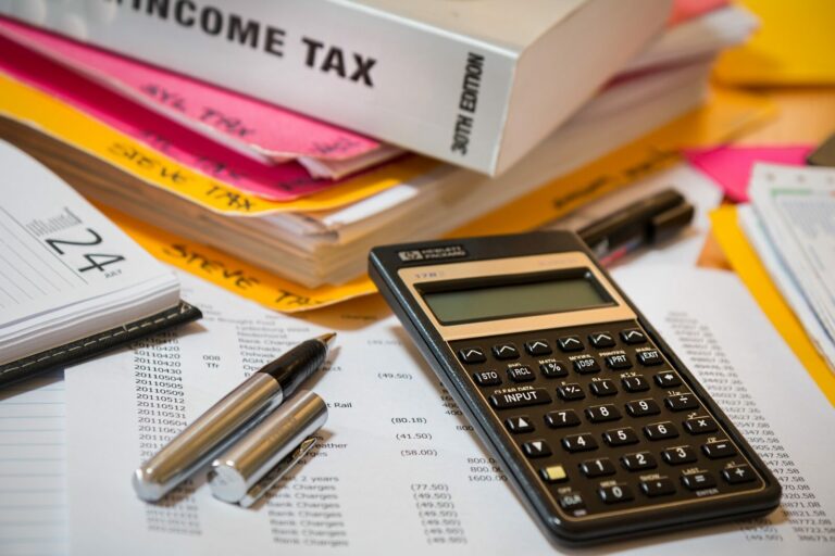 Calculator and pen on top of income tax documents